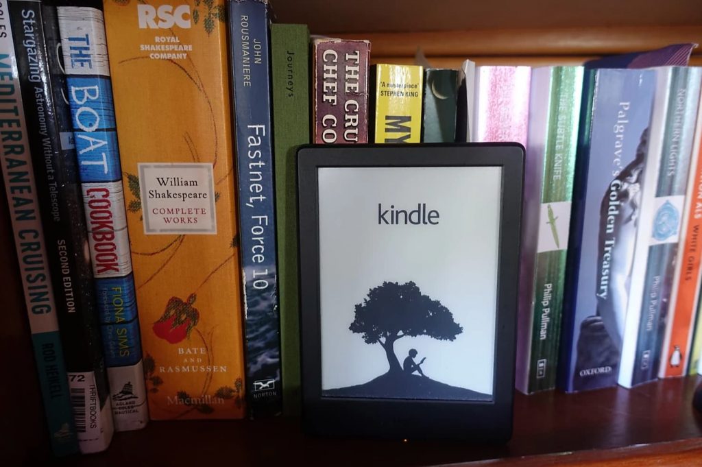 kindle ereader in front of a bookshelf