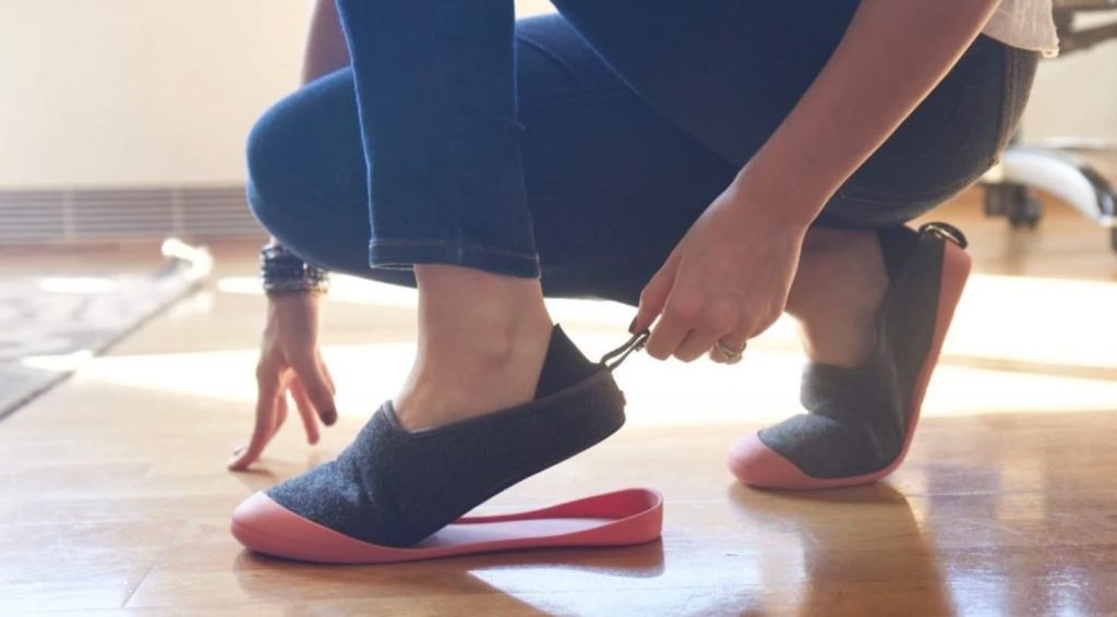 person kneeling putting a slipper on
