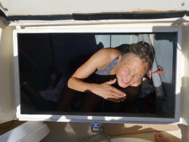 person in a cockpit locker of a boat