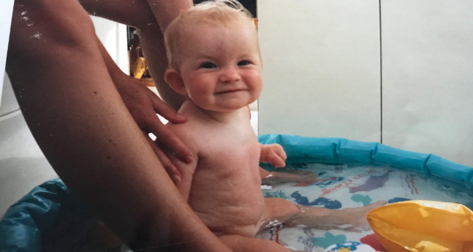 baby having a bath in a sailing boat cockpit
