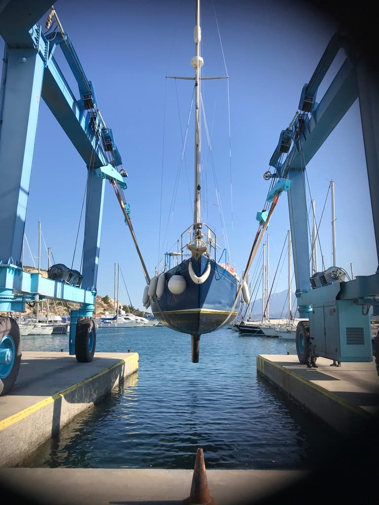 sailing boat yacht being hauled out by crane