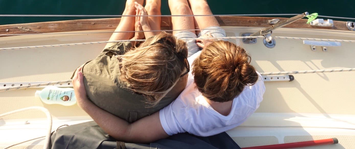 two girls hugging on a sailing boat