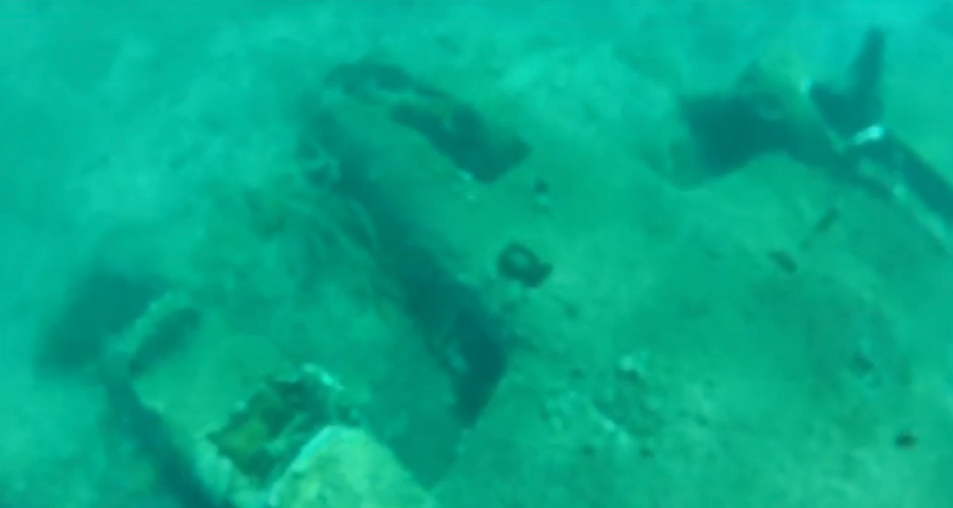 wreck of a bi-plane lying on it's back underwater