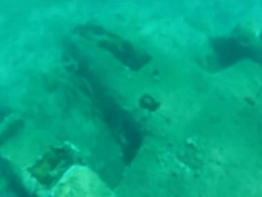 wreck of a bi-plane lying on it's back underwater