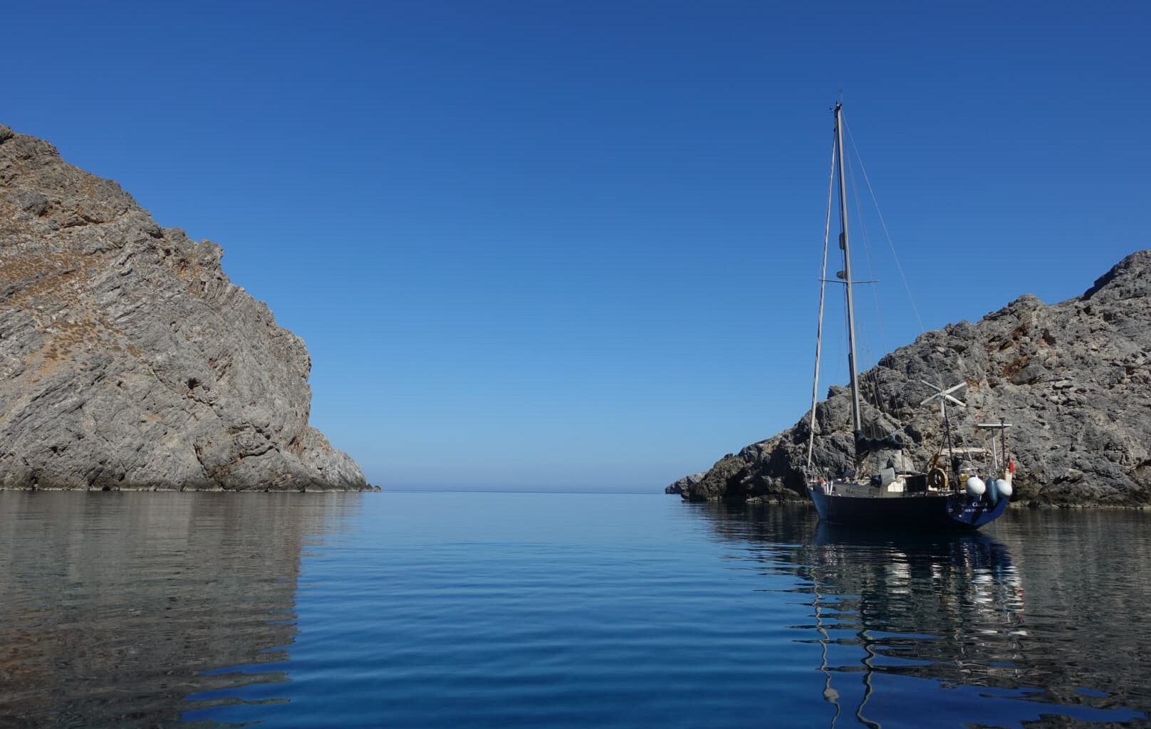 sailing boat at anchor in a cove