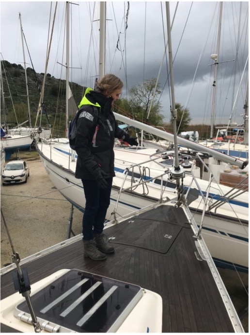 person measuring bow of sailboat