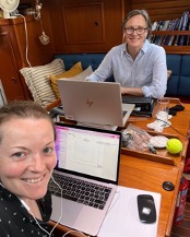 Two people working from a sailing boat