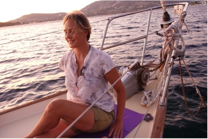 person doing yoga on the bow of a sailing boat