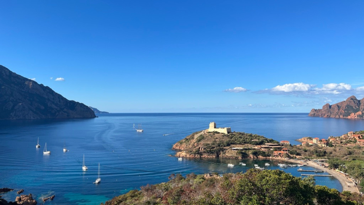 sailing boats at anchor off corsica in blue water and sunny sky